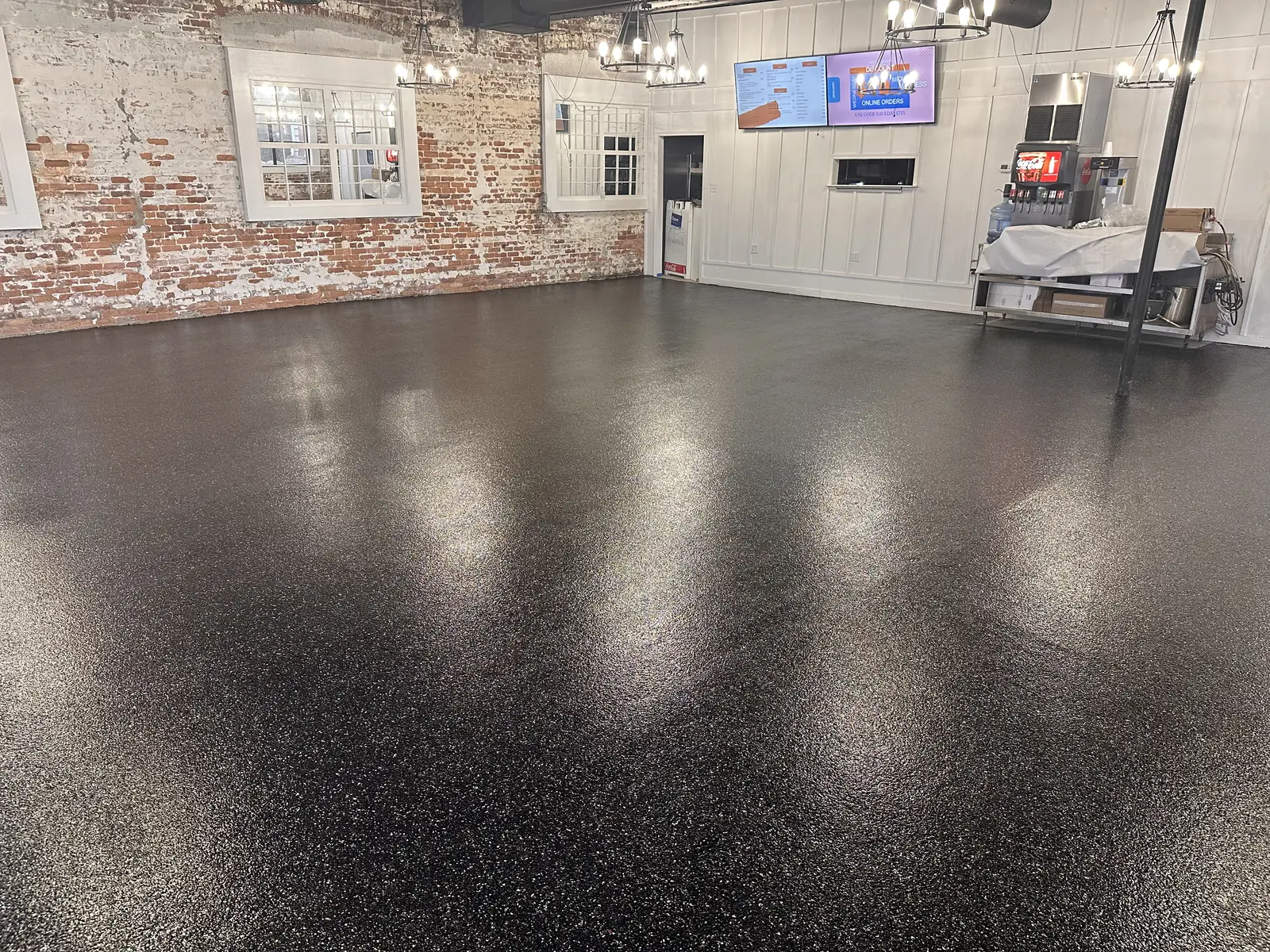 Black flake floor coating in a restaurant with brick walls