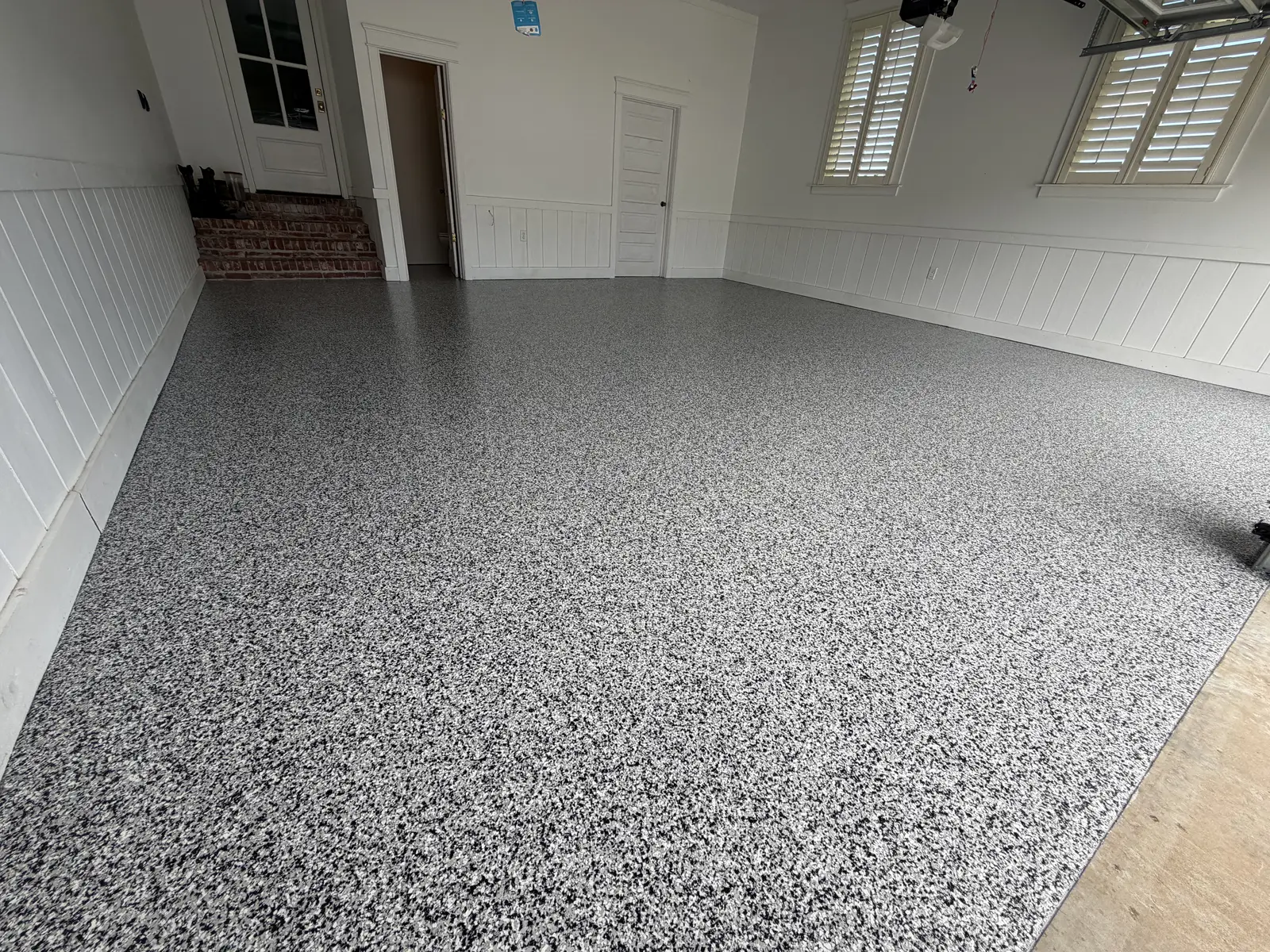 Wide view of a flake garage floor coating in an empty garage
