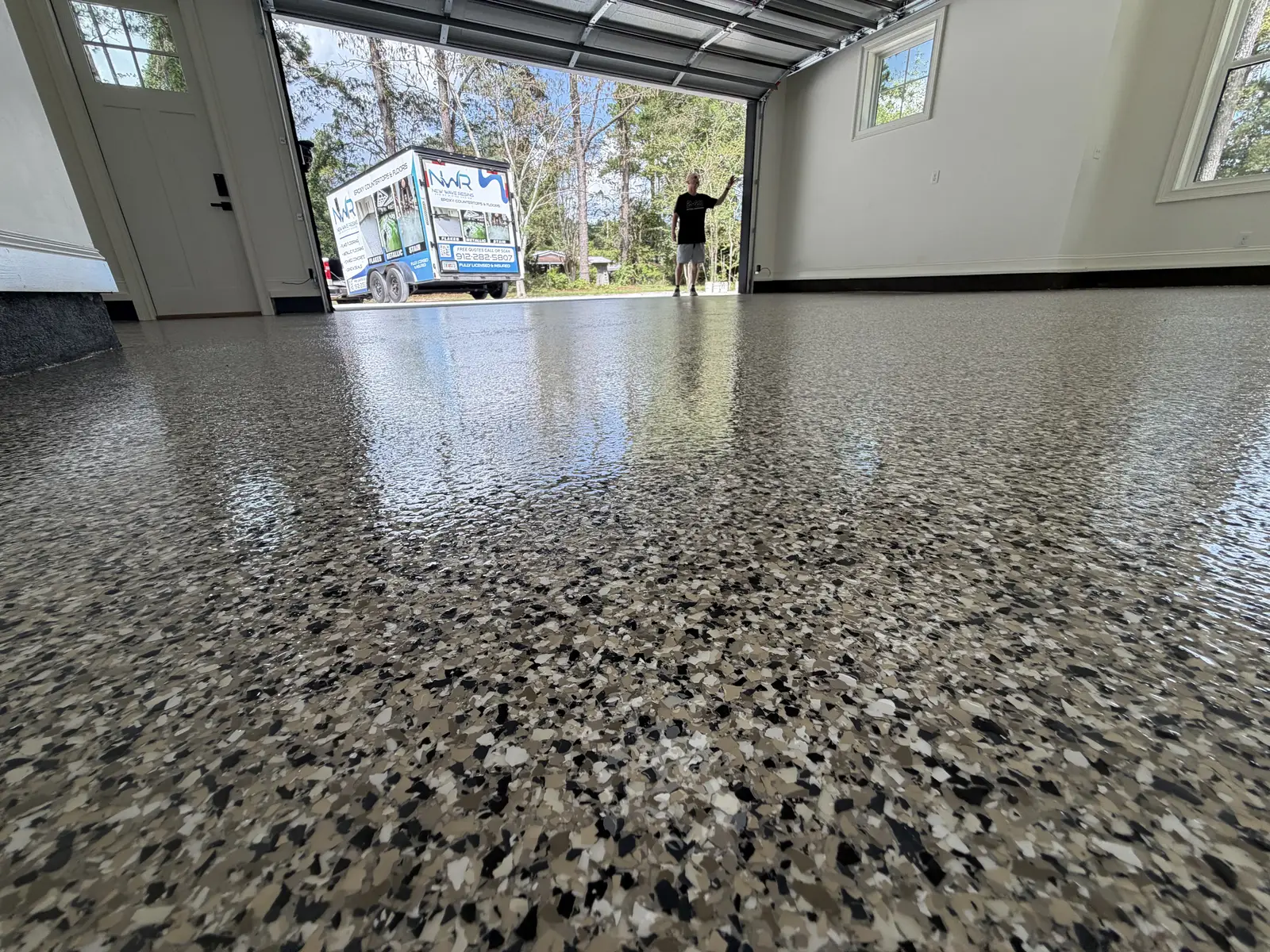 Glossy flake garage floor coating seen from floor level with the garage door open