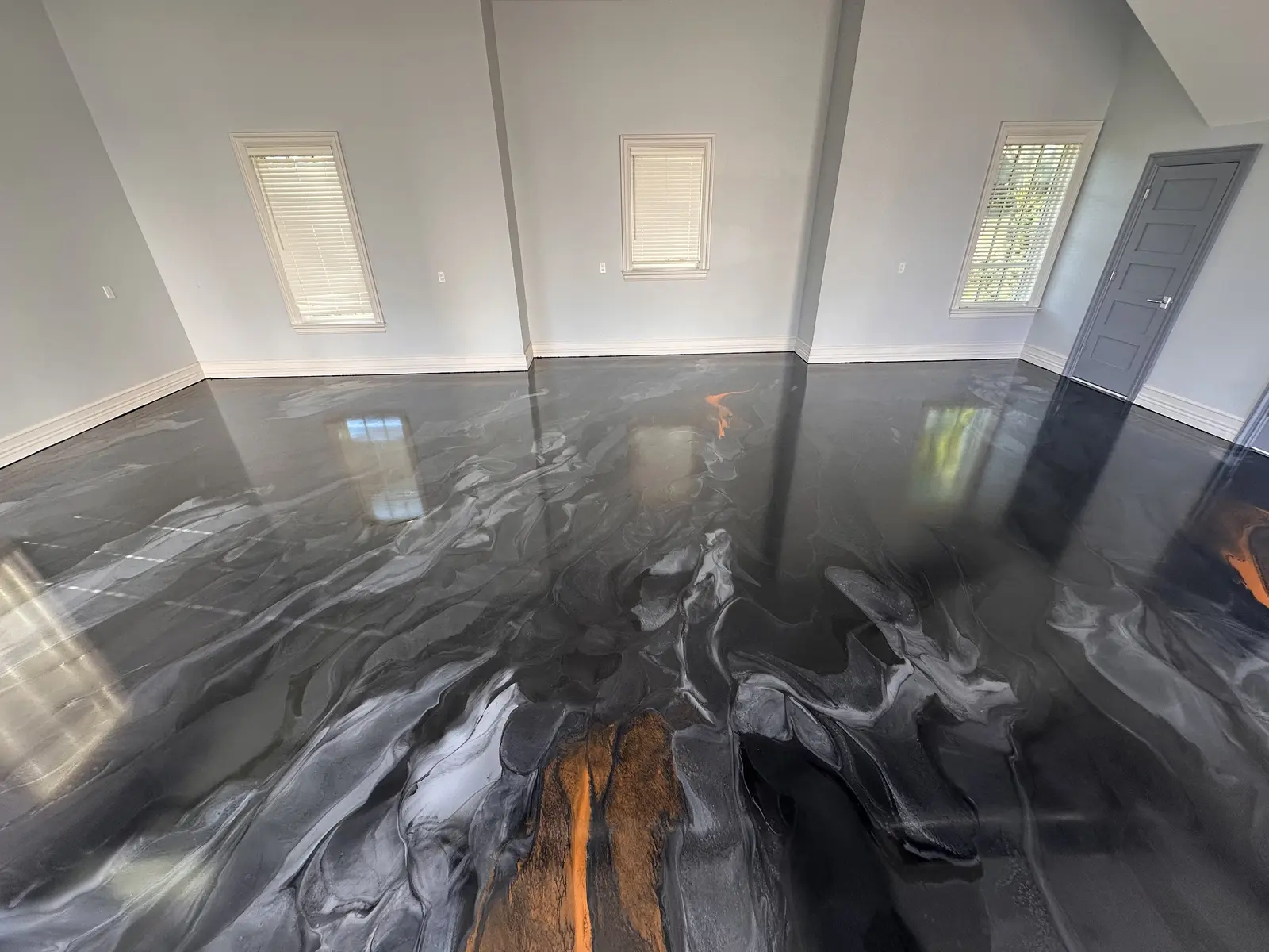 Black and silver metallic epoxy floor with a copper accent